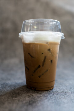 Iced Mocha coffee topped with milk foam in a glass. Close up