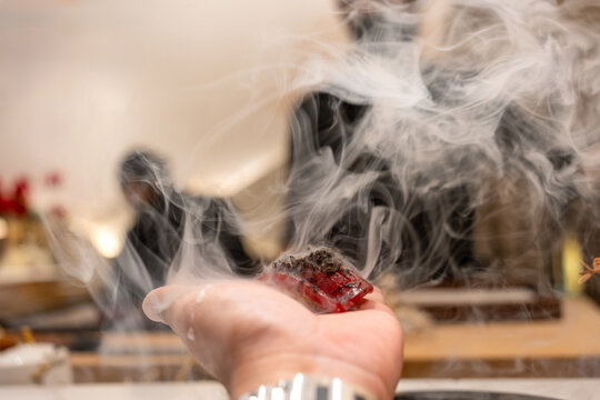 A single piece of sushi resting delicately on the palm. Japanese omakase restaurant