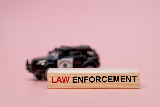 Law enforcement concept with police car and wooden block