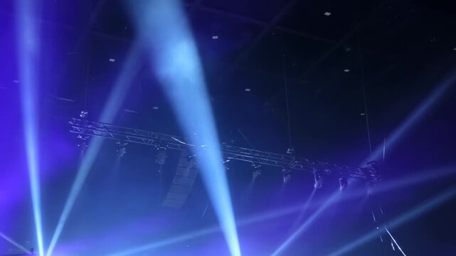 Blue stage lighting and concert sound system creating a vibrant party atmosphere