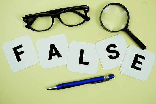 FALSE alphabet letters with magnifying glass, eye glasses and pen on yellow background