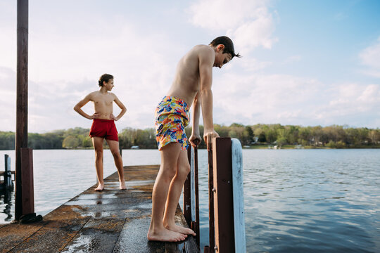 Big kids standing on lakeside dock after a swim