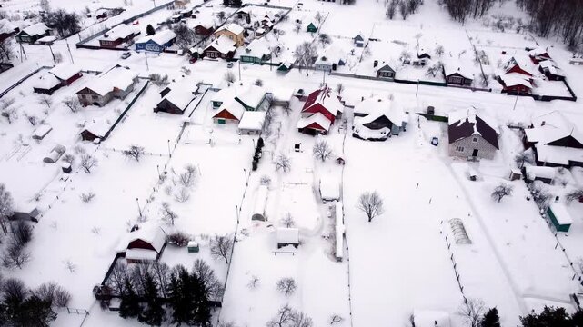 Cottage village in winter view from above snow drifts houses in the snow roofs in the snow top view with a drone. High quality 4k footage