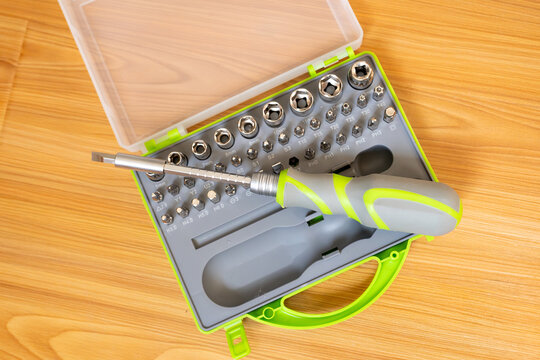 Close-up. Screwdriver with interchangeable bits. A set of steel bits for a screwdriver with a gray-green plastic handle. Concept: DIY home improvement