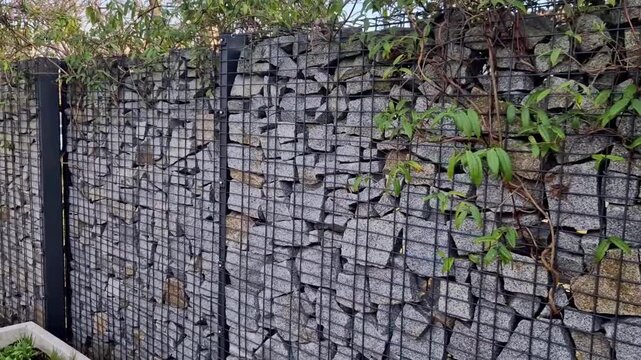 gabion wall,modern durable element of garden architecture.consists of wire baskets of galvanized steel cages, filled with natural stone. fencing of land, retaining for strengthening slopes. modern ben