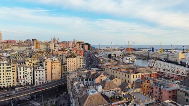 Forward drone flight over Genoa Porto Antico and historic center at sunset, stunning architecture and busy traffic road near harbour in Italy.