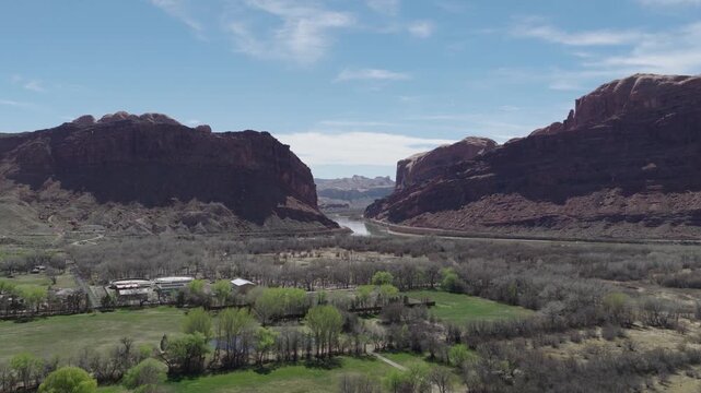 Moab Valley Utah United States with irrigated forage farmland transitioning into Moonflower Canyon along Colorado River flanked by Potash Road UT279 and Kane Springs Blvd, forward aerial hyperlapse