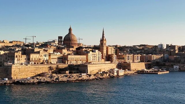 Basilica of Our Lady of Mount Carmel Bażilika tal Madonna tal Karmnu dominates Valletta Malta skyline with iconic dome above limestone buildings and fortified waterfront along Grand Harbour, static