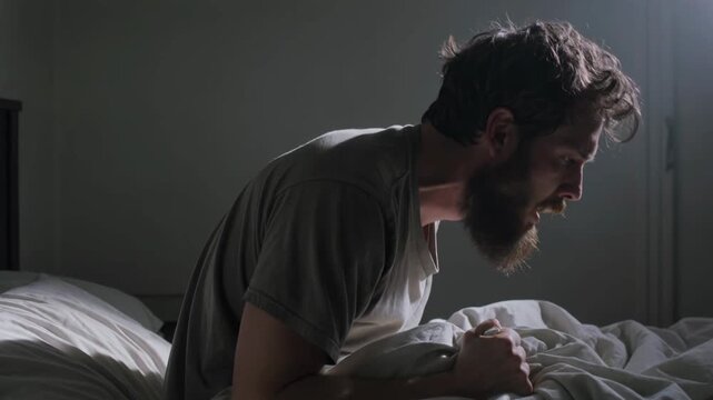 Adult man sitting in bed at night and yelling, visibly distressed and suffering from insomnia and mental health struggles