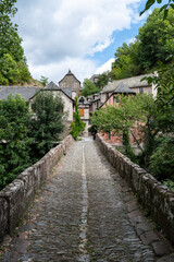 Fototapeta premium Ancient stone bridge at the entrance of the medieval village of Conques, Aveyron, France