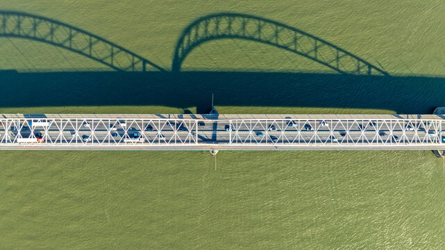 Topshot highway traffic on a bridge across a wide river in Europe