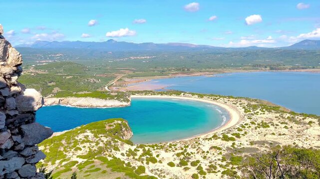 High angle panorama of Voidokilia omega-shaped beach and Gialova Lagoon from Old Navarino Castle, Greece. Nature preservation, freedom and Mediterranean serenity concept.