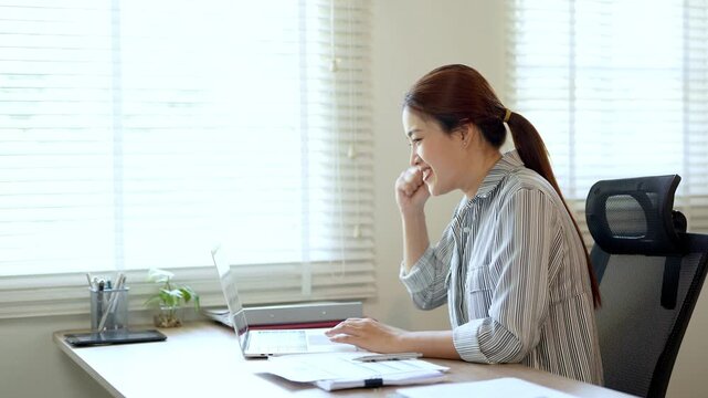 Excited asian office worker winner using laptop computer celebrating goal achievement. getting good news in email raising hands feeling happy  .