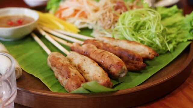 Vietnamese Grilled Pork Skewers Nem Nuong with Fresh Herbs and Vegetables
