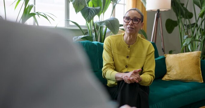 Therapist speaking in a counselling session, sitting on Sofa