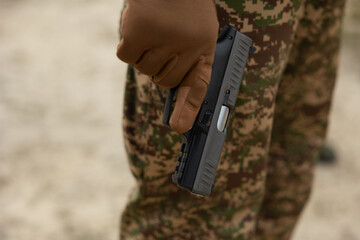 Obraz premium A boy in camouflage holds a gun