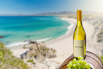 Fototapeta premium White wine bottle with grapes by sea beach