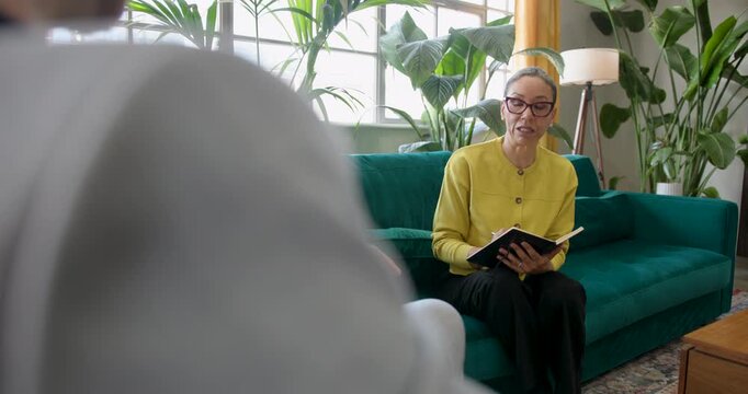 Therapist speaking in a counselling session, sitting on Sofa