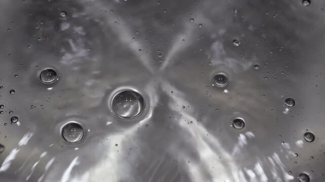 Close up of water boiling texture, water bubbles pattern, air bubbles backdrop in slow motion