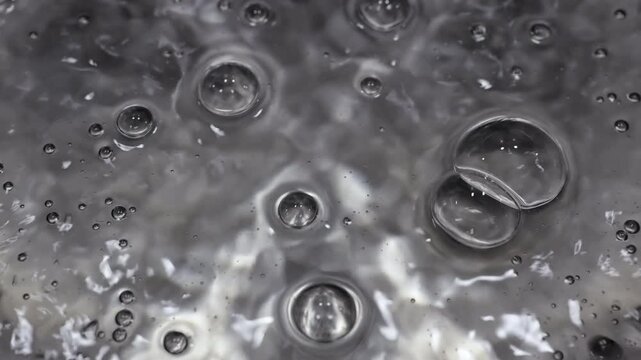 Close up of water boiling texture, water bubbles pattern, air bubbles backdrop in slow motion