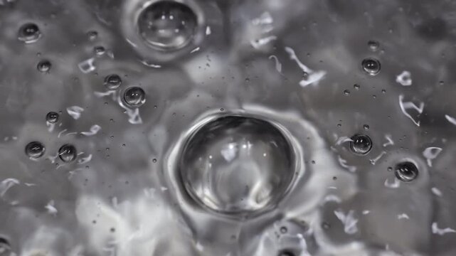 Close up of water boiling texture, water bubbles pattern, air bubbles backdrop in slow motion