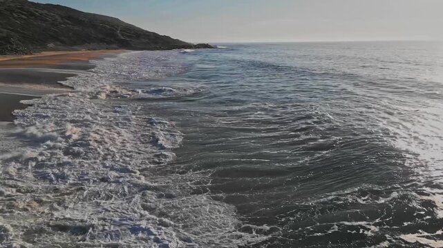 Waves at Praia do Salgado, Nazare, Portugal during a sunny day