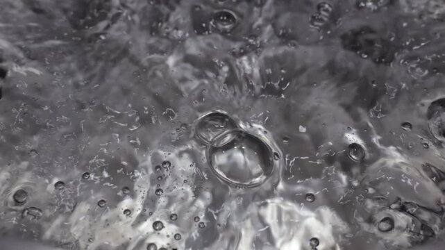 Close up of water boiling texture, water bubbles pattern, air bubbles backdrop in slow motion