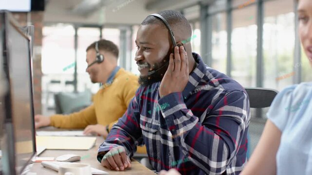 Man adjusting headset, answering call, typing and clicking mouse to assist customer at call center