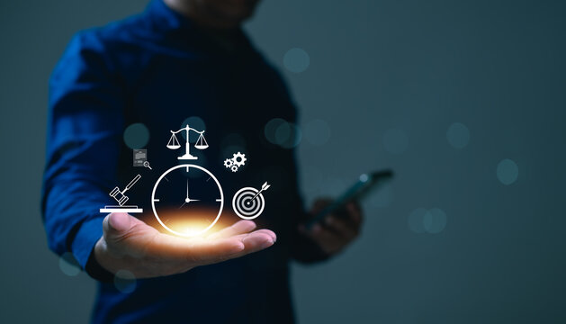 Businessman holding glowing justice scales icon, clock symbol, gavel, target, gear icons represents legal time management, business strategy, law firm efficiency, corporate compliance, professional