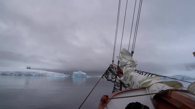 Cinematic POV shot from the bowsprit of the Schooner Amazone sailing through the Errera Channel toward Georges Point, Rong&eacute; Island, Antarctica