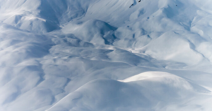 Winter landscape. Snow covered mountains with ski tracks, aerial view. Tourism destination concept.