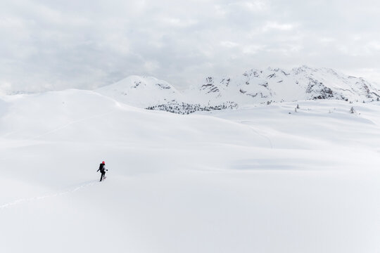 Winter travel, snowshoeing: Woman hikes in snow covered landscape, adventure and exploration in Sennes refuge,Sennes Braies Natural Park,Alto Adige,Veneto,Italy.