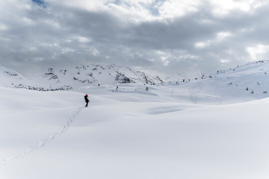 Travel, tourism: Hiker walks in snowy landscape with mountains, enjoying outdoor adventure and freedom. Sennes refuge,Sennes Braies Natural Park,Alto Adige,Veneto,Italy