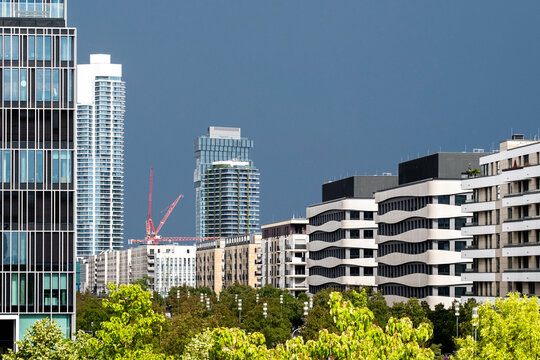 Residential apartment construction in Gallus Europaviertel Frankfurt as cranes rise against storm clouds and a wide city skyline in summer