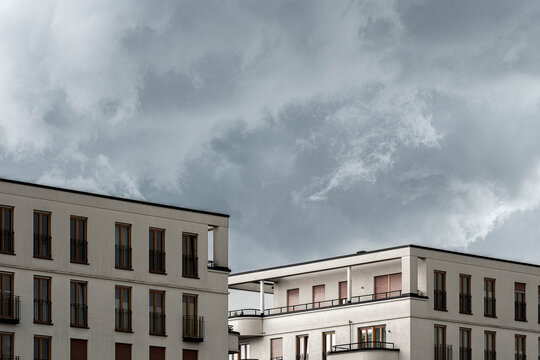 Storm clouds emphasize minimalism on a residential apartment building facade in Gallus Frankfurt Europaviertel during a moody summer day