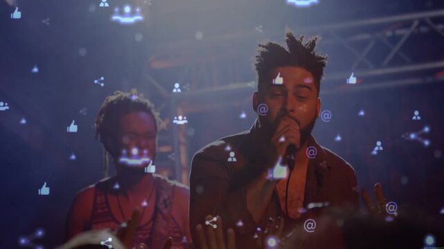 Singer starting music singing and gesturing engaging crowd while guitarist playing icons over stage