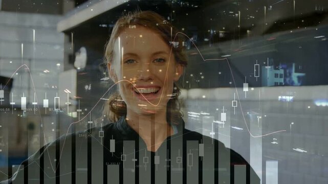 Reacting to frame, chef in dark jacket laughing then smiling in pro kitchen with financial charts