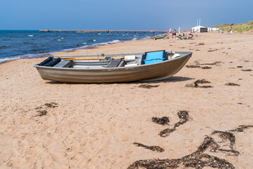 Naklejka premium A small boat for watching the beach with ropes on the sandy beach by the sea.