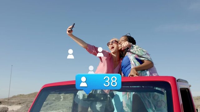 Two women standing in car, using phone seeking marketing growth as icons and follower count rising