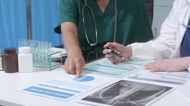 Doctors reviewing patient test results and x-ray on clinic desk with lab vials and medicine bottles, healthcare consultation, close-up hands and paperwork