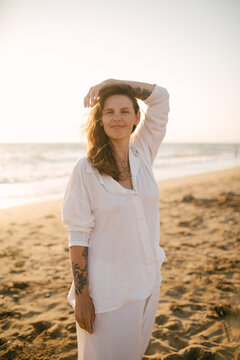 Beautiful 40 years old woman relaxing on the beach at sunset.
