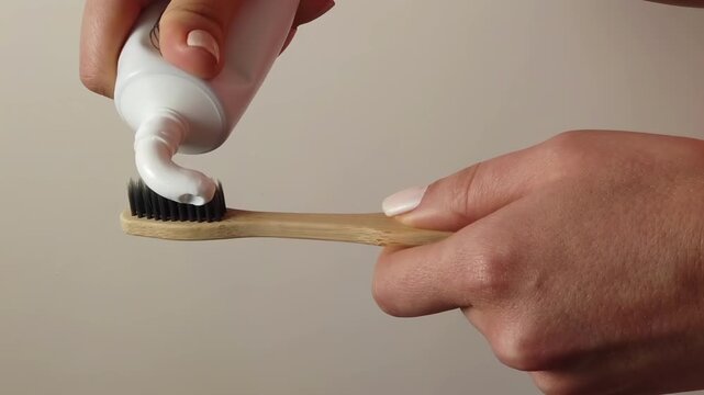 Applying toothpaste onto bamboo toothbrush close up shot dynamic motion clip healthcare hygiene concept.