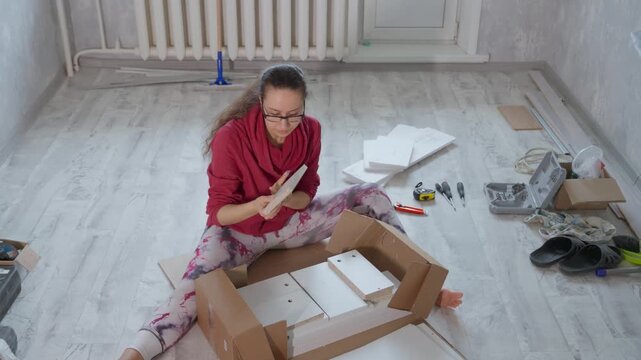 Lady Coordinating Tools And Checking Setup. Woman Sorting And Examining Installation Materials Carefully. Female Worker Methodically Arranging Panels And Thoroughly Inspecting Layout