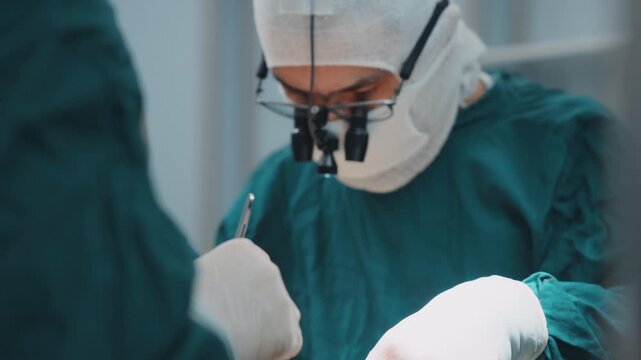 Group of surgeons performing a surgical procedure in an operating room under bright surgical lighting. Sterile environment and professional healthcare 