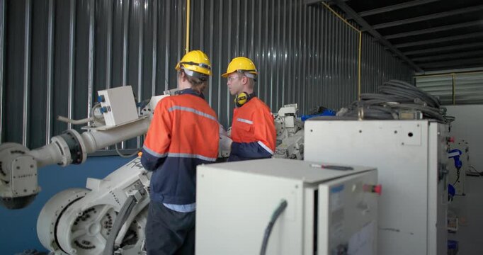 Robotic technicians use clamp meter to measure current within robotic arm. Troubleshooting process, aimed at diagnosing electrical issues, shorts, overloads, inefficiencies in electrical system.
