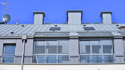 Fototapeta premium Modern residential structure showcasing a contemporary design with sloped roof, big windows and balconies.