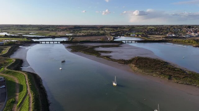 Aerial view of Manningtree, Essex on the River Stour with boats under blue skies