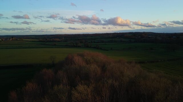 Soft dusk sunset light passes over farmers fields of Harrogate in North Yorkshire with soft colours and orange glow and shadows