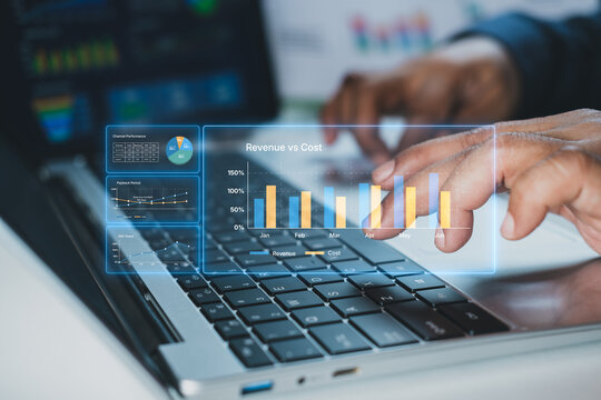 Business data analytics dashboard with revenue vs cost chart overlay on laptop, financial KPI monitoring for marketing performance, SaaS growth tracking, ROI analysis, digital strategy optimization