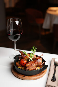 Whole Roasted Quail with Golden Potatoes and Grilled Tomato.